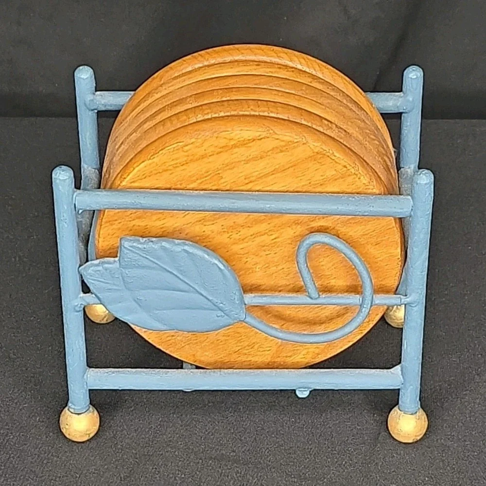 a vintage wooden drink coasters in a blue metal  holder with leaf-shaped accents